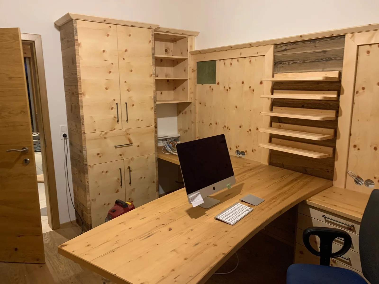 Arbeitszimmer aus hellem Holz mit Schrank, Schreibtisch und Wandborden