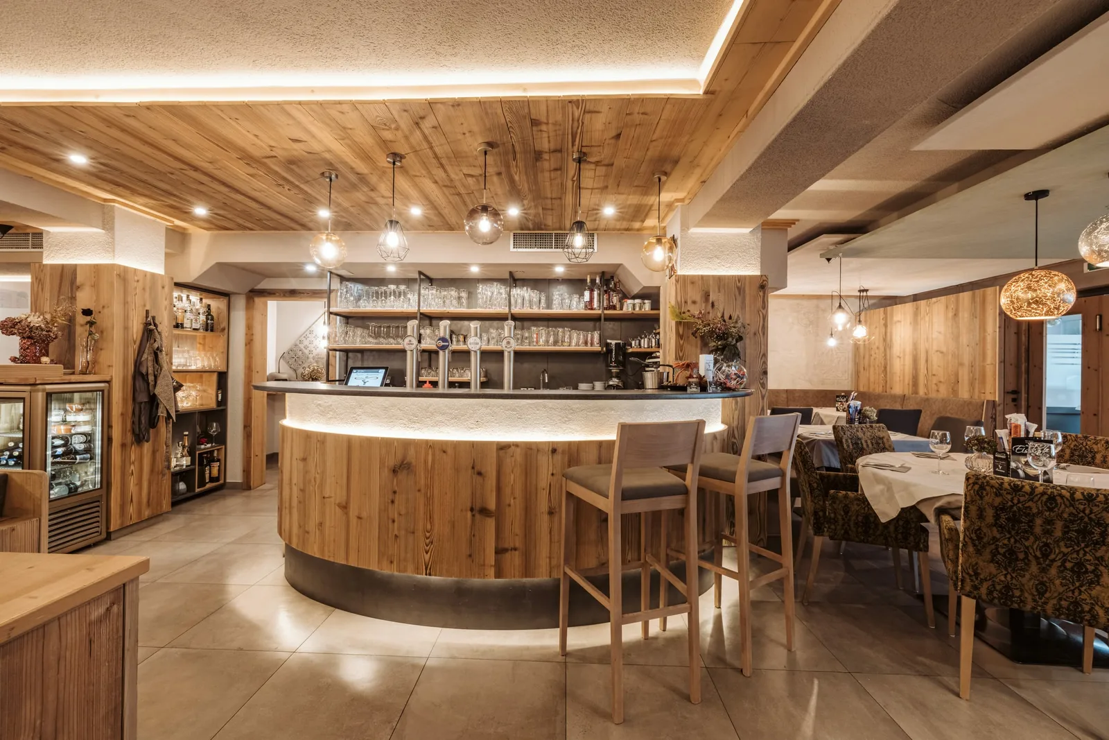Runde Bar aus Holz mit Lichtfuge, Barhocker und Gläserregal